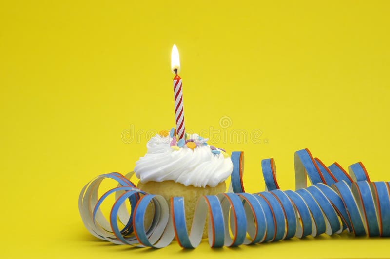 Happy Birthday 2. Cupcake with frosting and burning red candle against yellow background. Surrounded by party decoration royalty free stock images Happy Birthday 2. Cupcake with frosting and burning red candle against yellow background. Surrounded by party decoration royalty free stock images