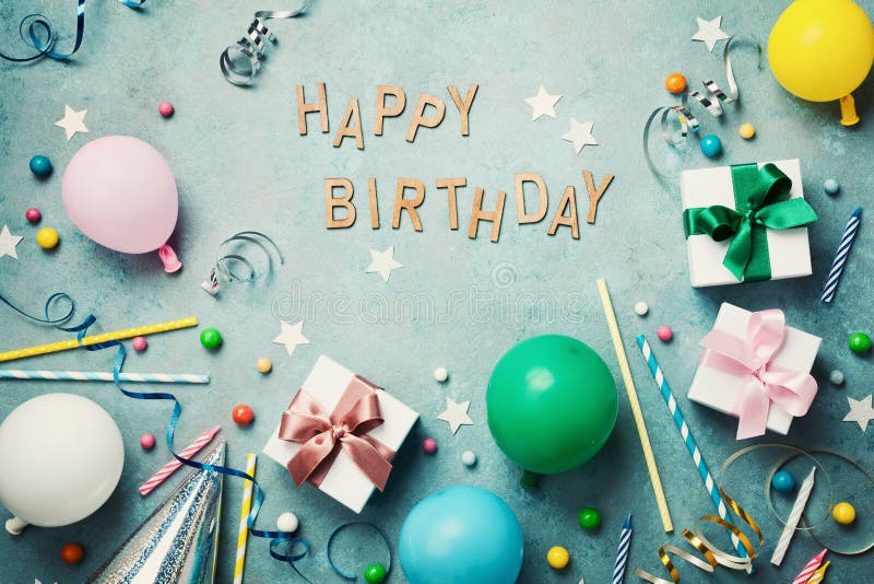 Happy birthday background or greeting flyer. Colorful holiday supplies on blue vintage table top view. Flat lay style. royalty free stock photography Happy birthday background or greeting flyer. Colorful holiday supplies on blue vintage table top view. Flat lay style. royalty free stock photography