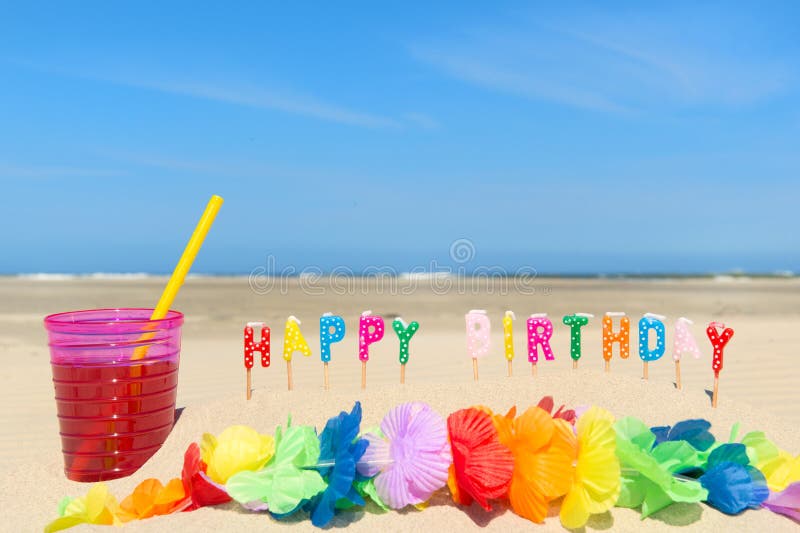 Glass lemonade with drinking straw and happy birthday candles at the beach. Glass lemonade with drinking straw and happy birthday candles at the beach