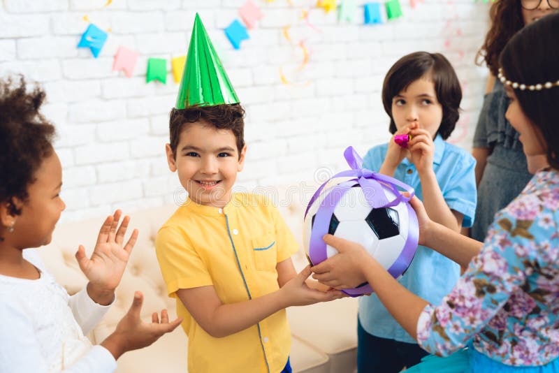 Happy birthday boy receives football ball as birthday gift. Happy birthday party. Little children on birthday celebrations stock photo Happy birthday boy receives football ball as birthday gift. Happy birthday party. Little children on birthday celebrations stock photo