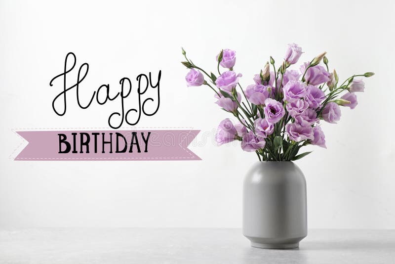 Happy Birthday! Eustoma flowers in vase on table near white wall