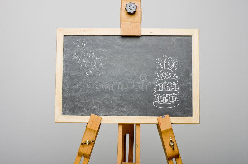 Happy birthday written on birthday cake with candles on top, on black chalkboard, easel painting, stand stock image Happy birthday written on birthday cake with candles on top, on black chalkboard, easel painting, stand stock image