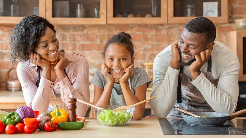 Happy Black Family Cooking Healthy Dinner Together at Kitchen Stock