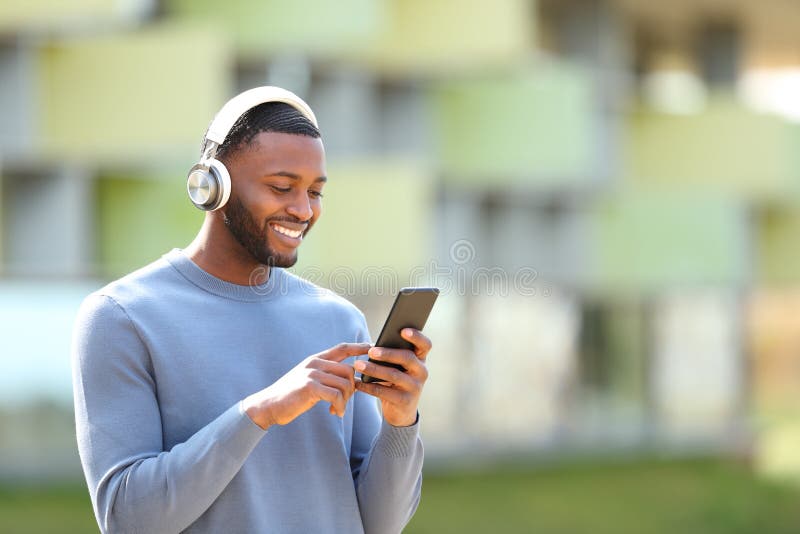 Happy black man listening to music in the street