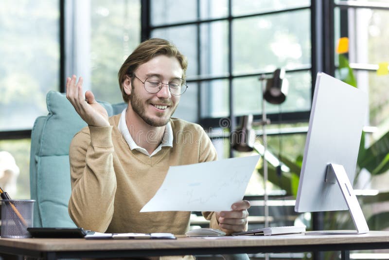 Happy blond man working inside an office building, young financier working with documents royalty free stock image