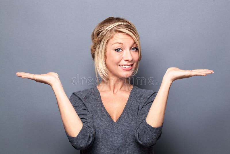 Happy blond woman displaying something equal on empty hands stock photography Happy blond woman displaying something equal on empty hands stock photography