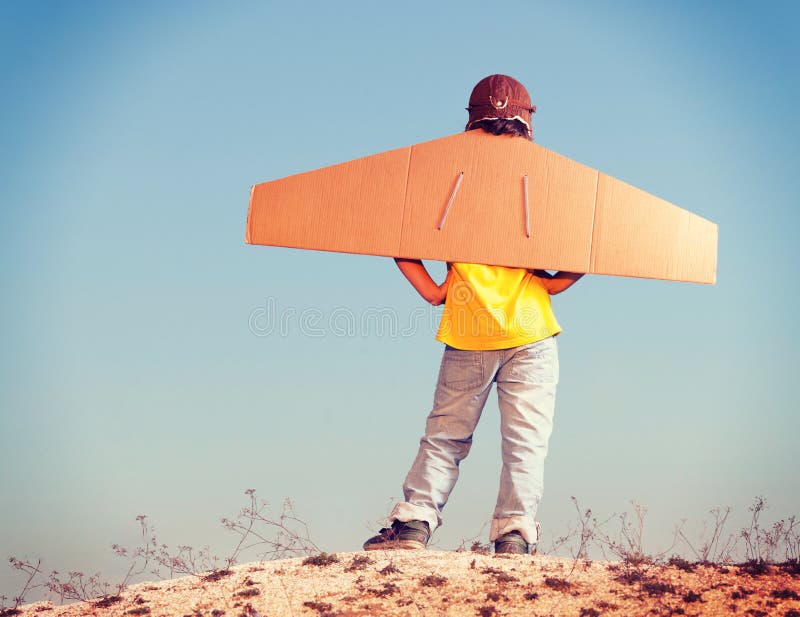 Happy boy with cardboard boxes of wings against sky dream of fly stock images Happy boy with cardboard boxes of wings against sky dream of fly stock images