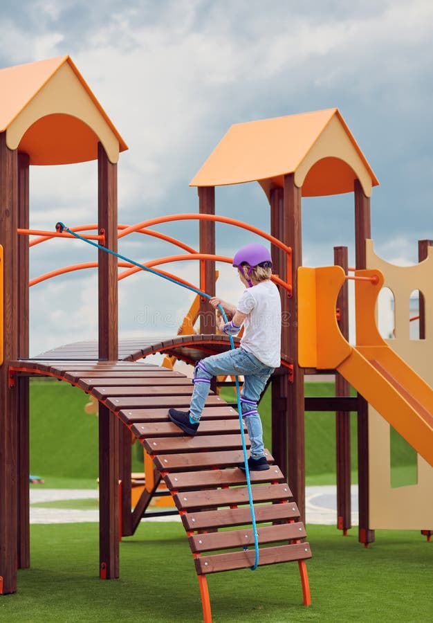 Happy boy climbing into colorful activity tower on the playground, children development and entertainment, playground equipment royalty free stock photography Happy boy climbing into colorful activity tower on the playground, children development and entertainment, playground equipment royalty free stock photography