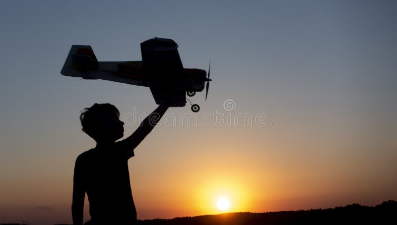 Happy Boy corre con un aereo giocattolo su un campo alla luce del tramonto I bambini giocano a giocare con l'aereo giocattolo sog