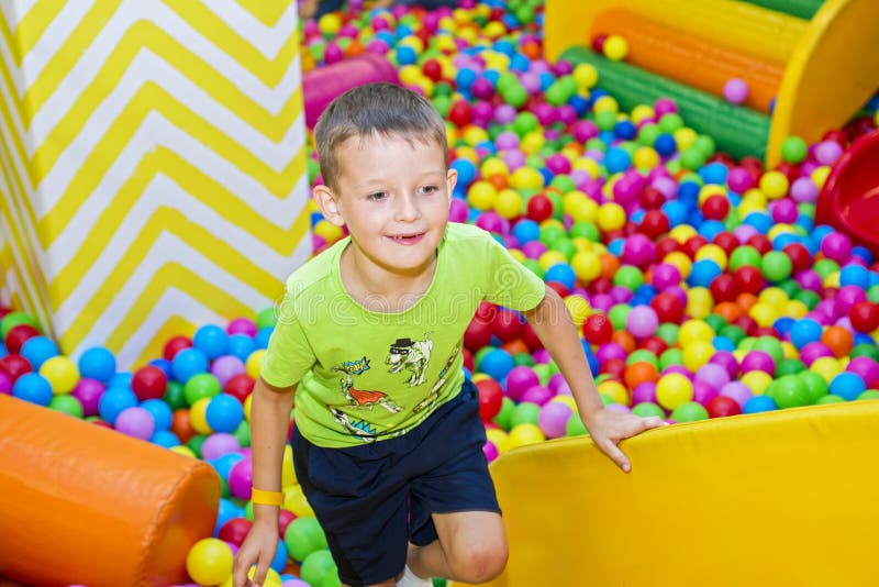 Happy boy is having fun in kids amusement park and indoor play center.  Activity toys for little kid