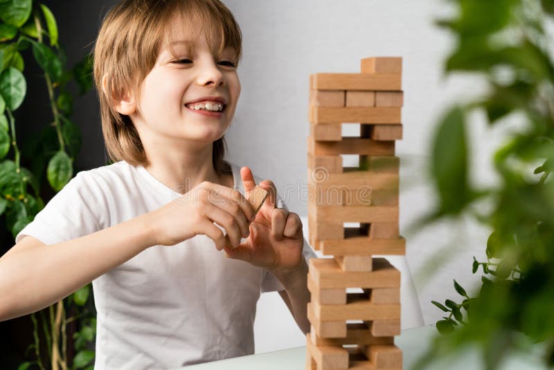 Garçon Jouant Au Jeu De Société Construisant Une Tour De Cubes En Bois Jeu  De Logique Jenga Pour Le Développement De L'enfant