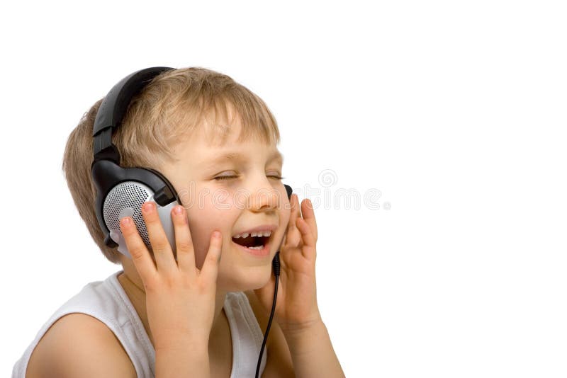 A happy young boy enjoys listening to his favorite music on a headset. A happy young boy enjoys listening to his favorite music on a headset.