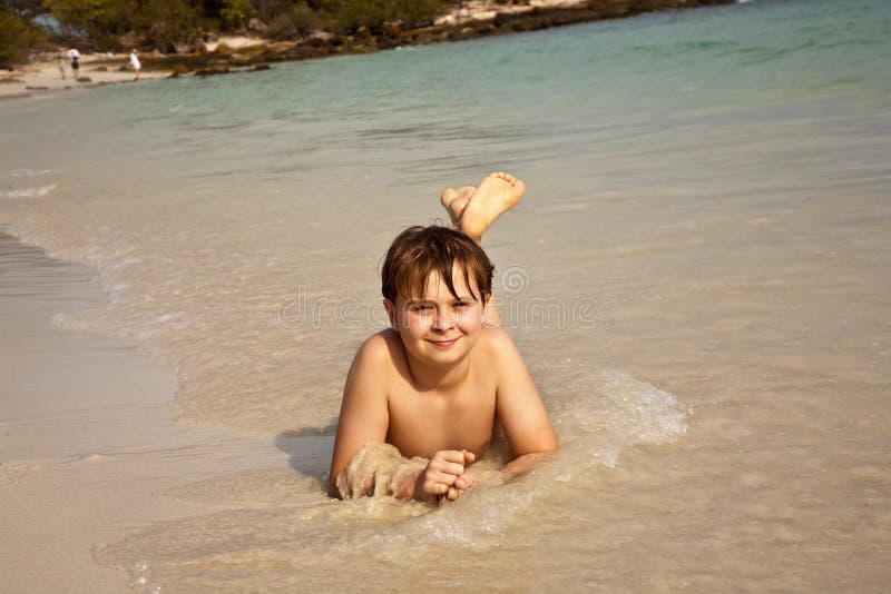 Happy boy lying at the beach