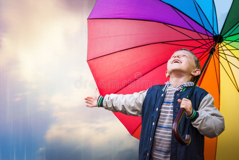 Happy boy portrait with bright rainbow umbrella