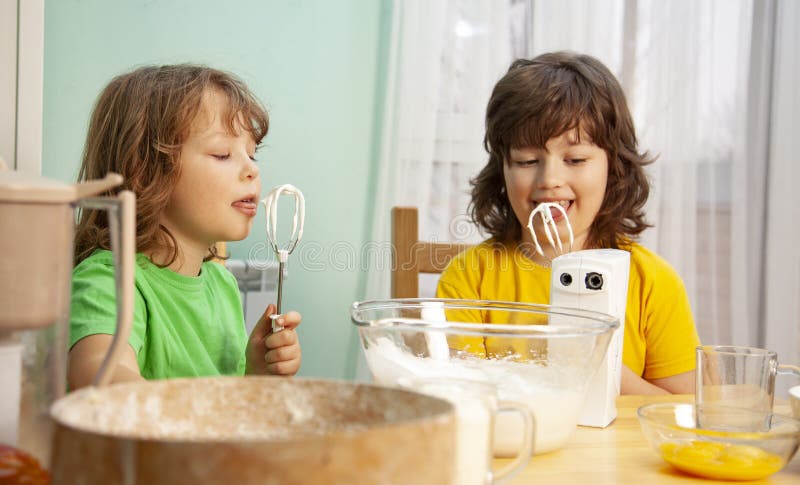 Happy boy preparing the cream, bake cookies in the kitchen. family funny stock images Happy boy preparing the cream, bake cookies in the kitchen. family funny stock images