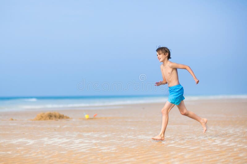 Happy boy running on a beautiful tropical beach