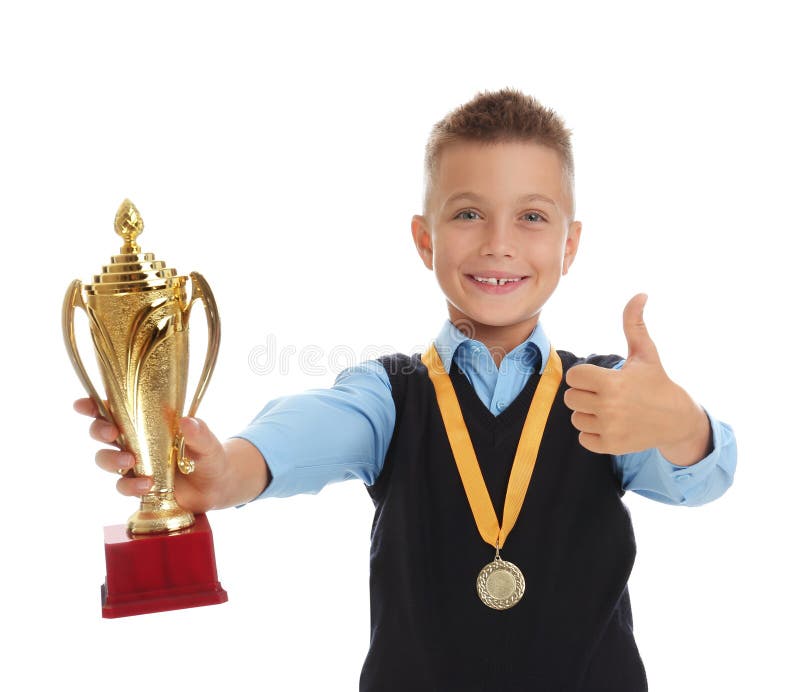 Happy boy in school uniform with golden winning cup and medal isolated