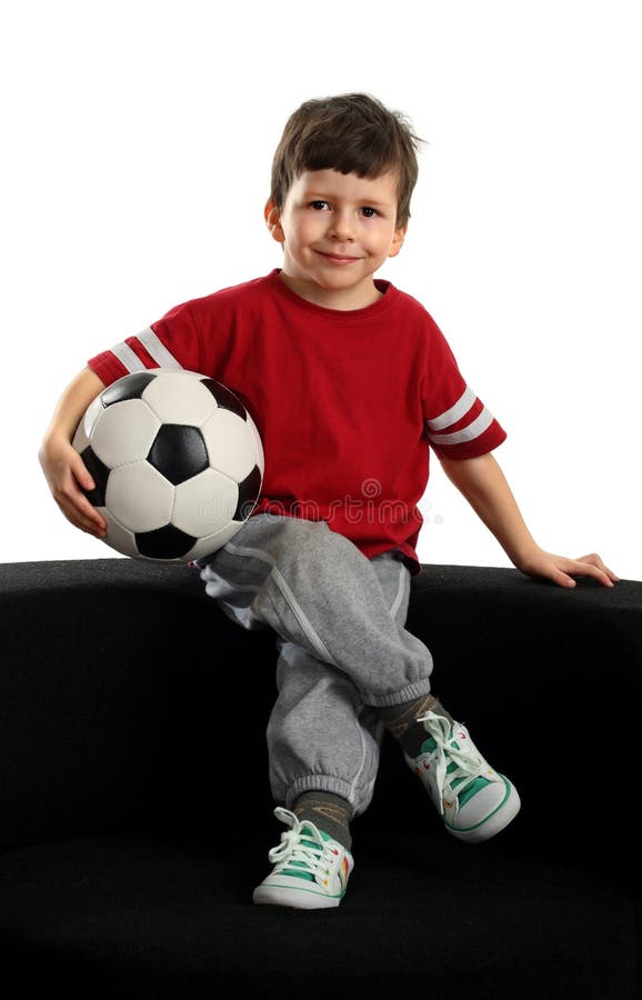 Happy boy sits with the soccer ball