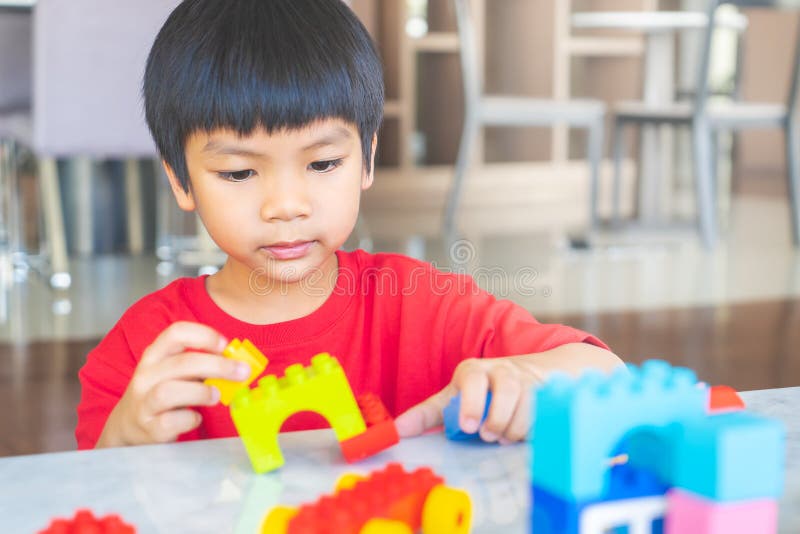 Boy Stacking Toy Blocks on a Living Room for Educational Toy Stock