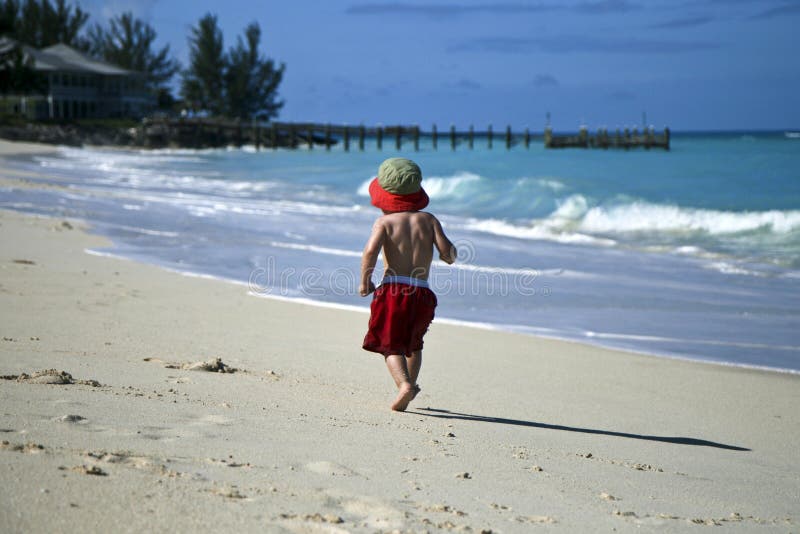 Happy boy walking alone on the beach