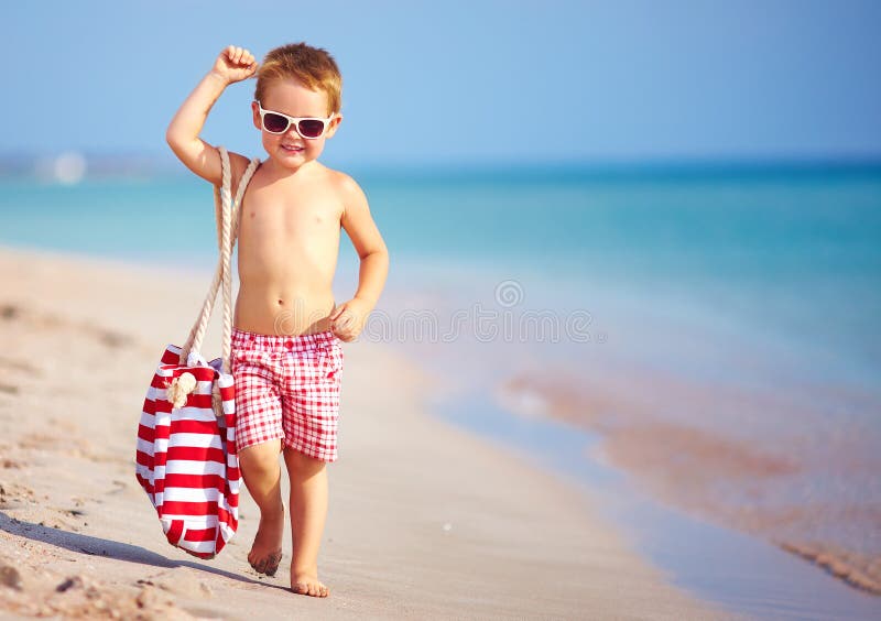 Happy boy walking the summer beach