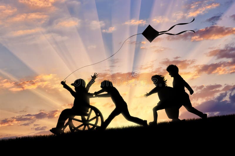 Happy boy in wheelchair playing with children and kite