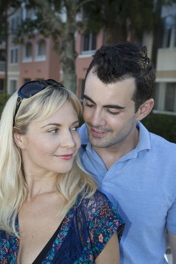 Happy boyfriend looking down at his blond girlfriend royalty free stock photos