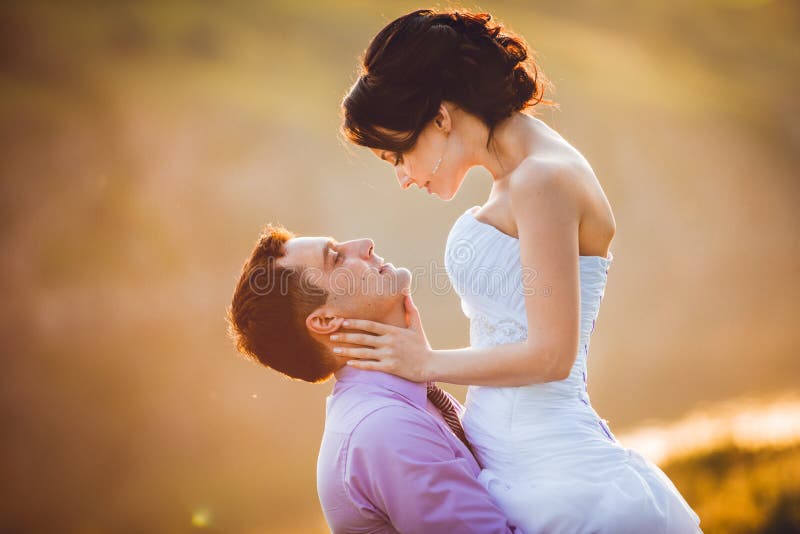 Happy bride and groom celebrating wedding day. Married couple in front of sunset. Toned image royalty free stock photo Happy bride and groom celebrating wedding day. Married couple in front of sunset. Toned image royalty free stock photo