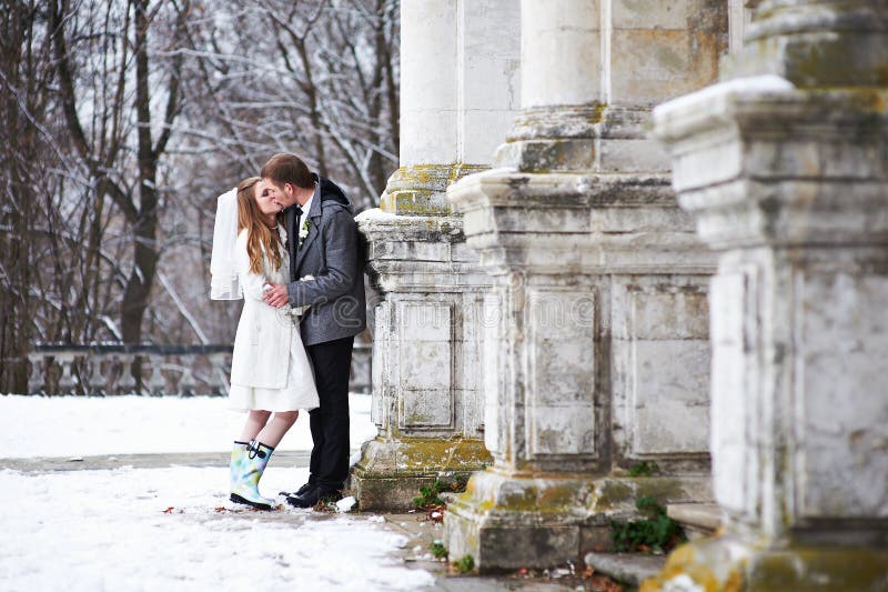 Happy bride and groom kissing near old castle