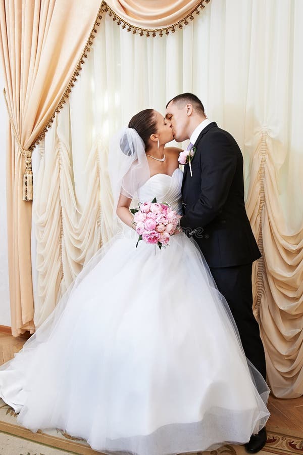 Happy bride and groom kissing on solemn registration