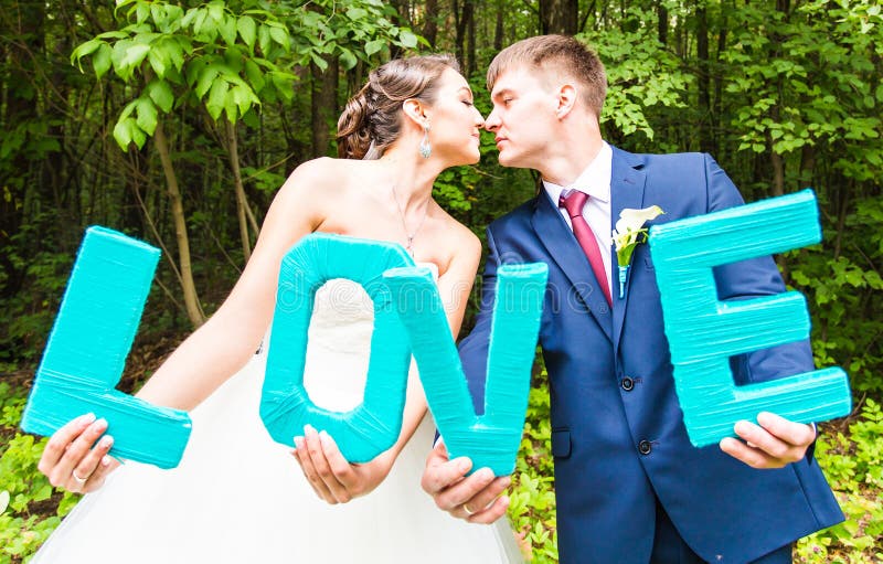 Happy bride and groom and LOVE letters royalty free stock image