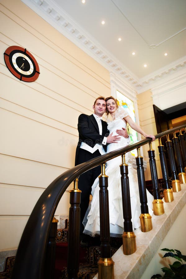 Happy bride and groom at luxurious stairs