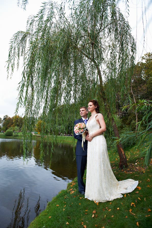 Happy bride and groom near lake