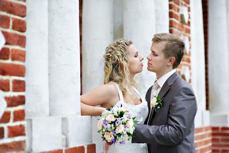 Happy bride and groom near palace