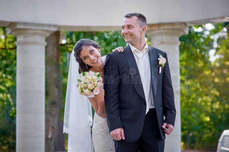 Happy bride and groom walking among the columns royalty free stock photography Happy bride and groom walking among the columns royalty free stock photography