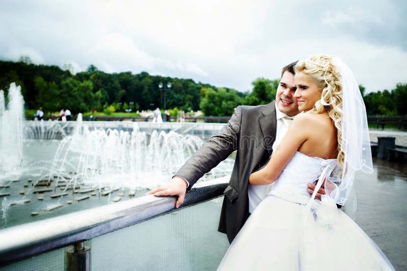 Happy bride and groom at wedding walk on bridge