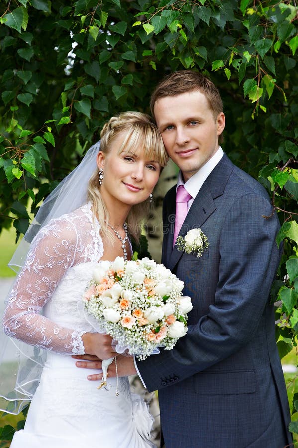 Happy bride and groom in wedding walk in park