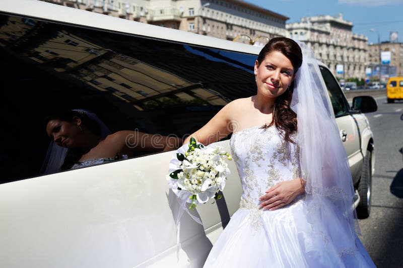 Happy bride near wedding limo