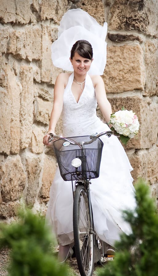 Happy bride riding a bike