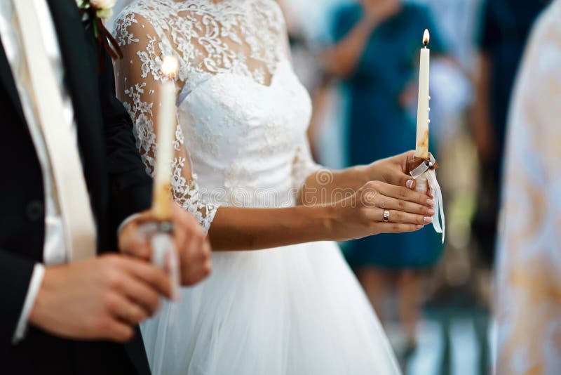 Happy bride and stylish groom holding candles wedding ceremony, wedding couple at matrimony in church, emotional moment, religion stock photography Happy bride and stylish groom holding candles wedding ceremony, wedding couple at matrimony in church, emotional moment, religion stock photography