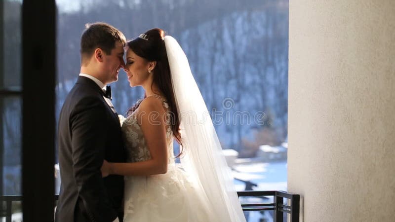 Happy brides hug by the window