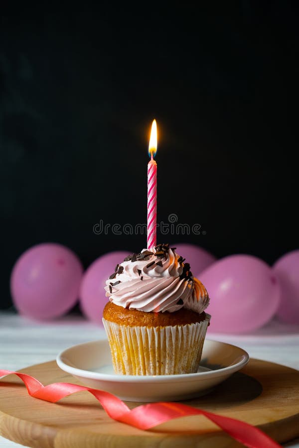 Happy brithday cupcake with a candle on a black background stock photography Happy brithday cupcake with a candle on a black background stock photography