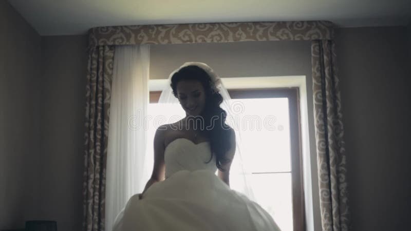 Happy brunette bride dancing. Attractive woman in wedding dress getting ready for ceremony, enjoying the day.