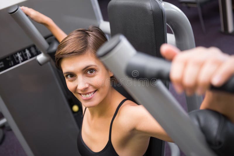 Happy Brunette Using Weights Machine for Arms Stock Photo - Image of ...