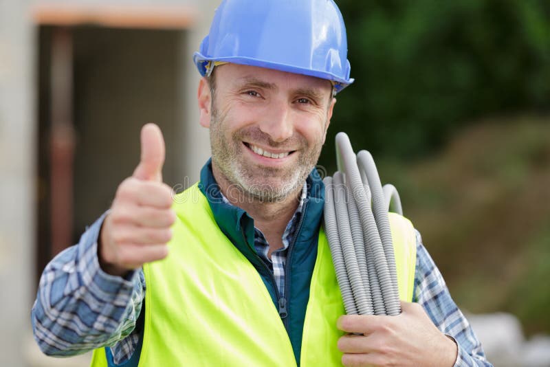 Happy builder man laughing and making thumbs up outdoors royalty free stock photography Happy builder man laughing and making thumbs up outdoors royalty free stock photography