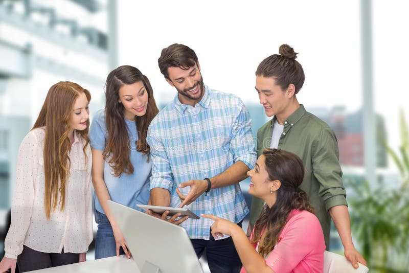 Happy business people at a desk looking at a tablet