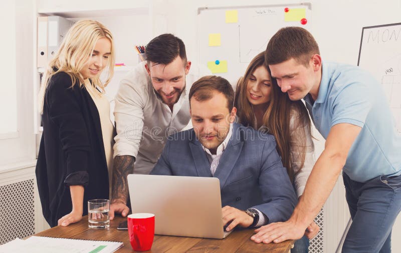 Happy business people team together look at laptop in office stock photography Happy business people team together look at laptop in office stock photography