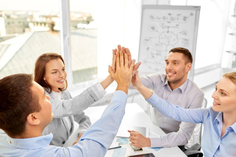 Happy business team making high five at office stock images Happy business team making high five at office stock images