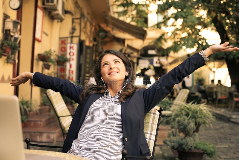 Happy business woman at cafe listening music, arms up. stock image Happy business woman at cafe listening music, arms up. stock image