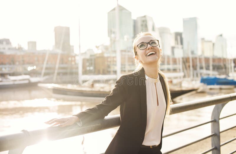 Happy business woman laughing outdoors near the river
